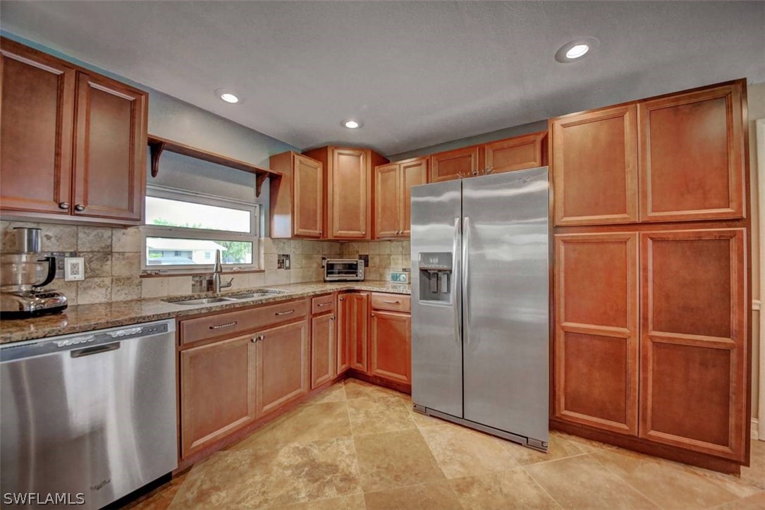 1650 North Mayfair Road Fort Myers, FL 33919 - Photo 6 of 24 a kitchen with granite countertop stainless steel appliances a refrigerator sink and microwave