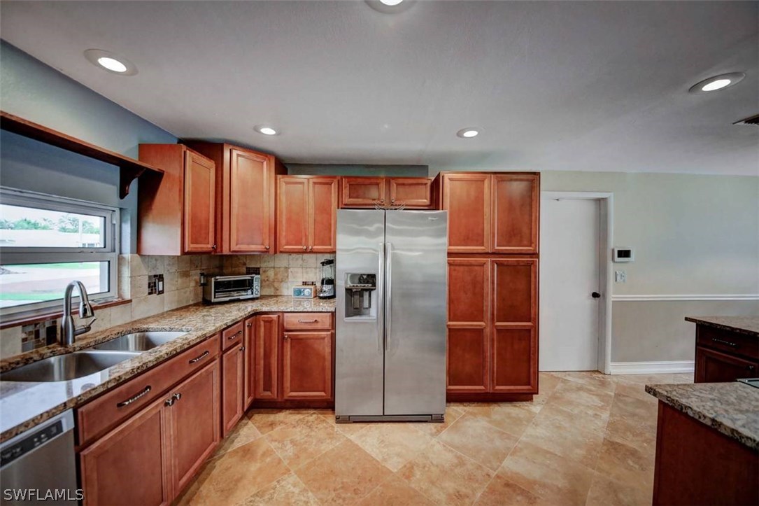 1650 North Mayfair Road Fort Myers, FL 33919 - Photo 9 of 24 a kitchen with stainless steel appliances granite countertop a refrigerator a sink a stove a microwave and island