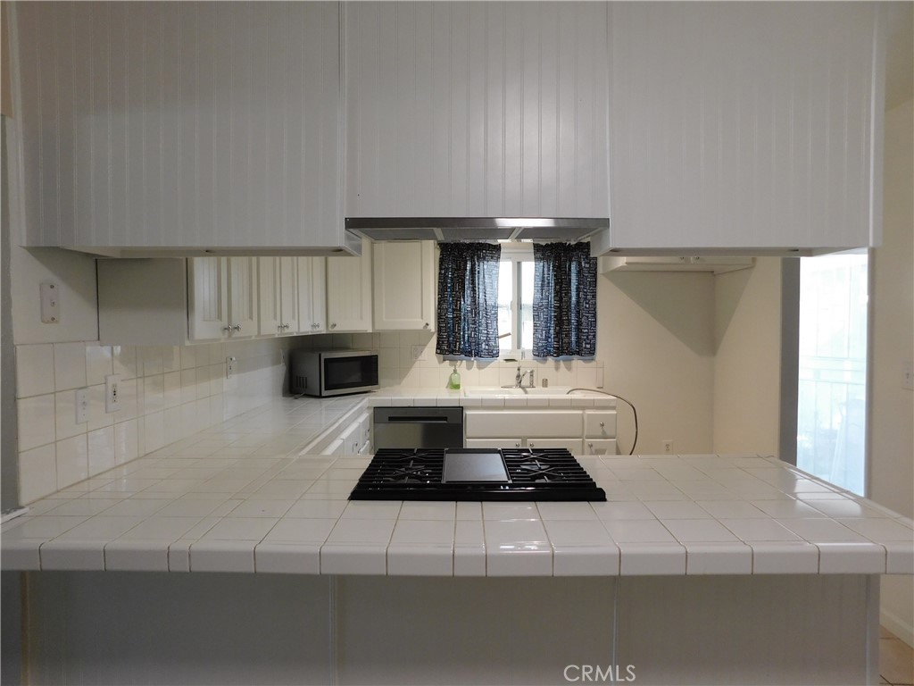 755 Valley View Avenue, Unit B Monrovia, CA 91016 - Photo 6 of 25 a kitchen with a stove and white cabinets