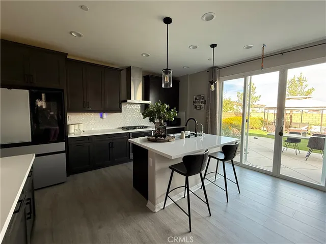 a kitchen with a sink a kitchen island a stove a table and chairs