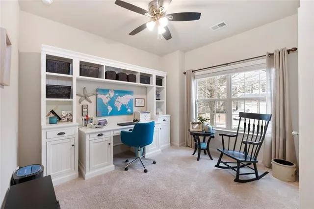 a view of a workspace with furniture and a window