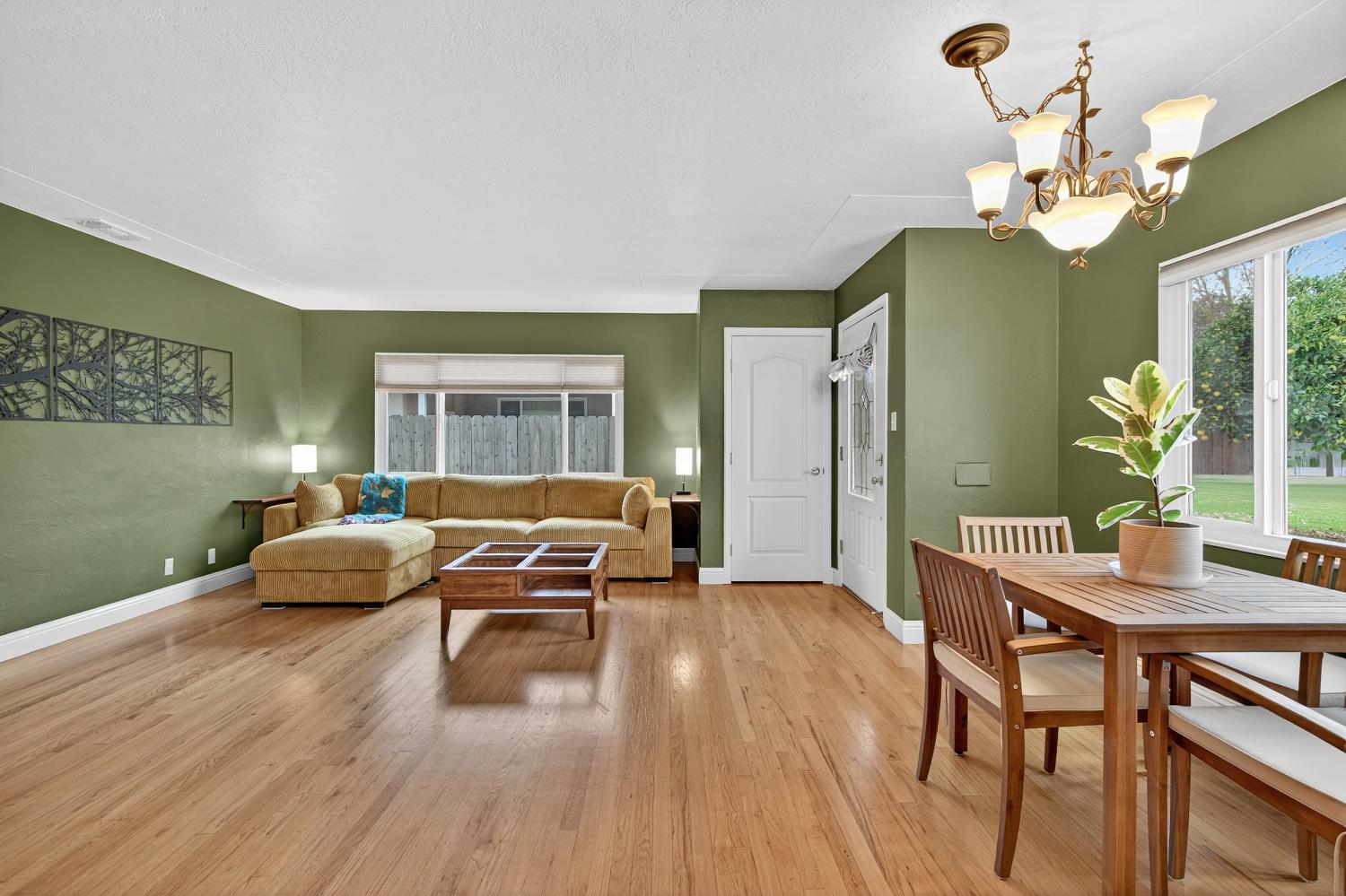 1507 West Locust Street Lodi, CA 95242 - Photo 6 of 28 a dining room with wooden floor a chandelier a wooden table and chairs