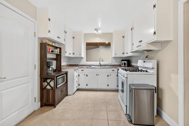 a kitchen with white cabinets and stainless steel appliances