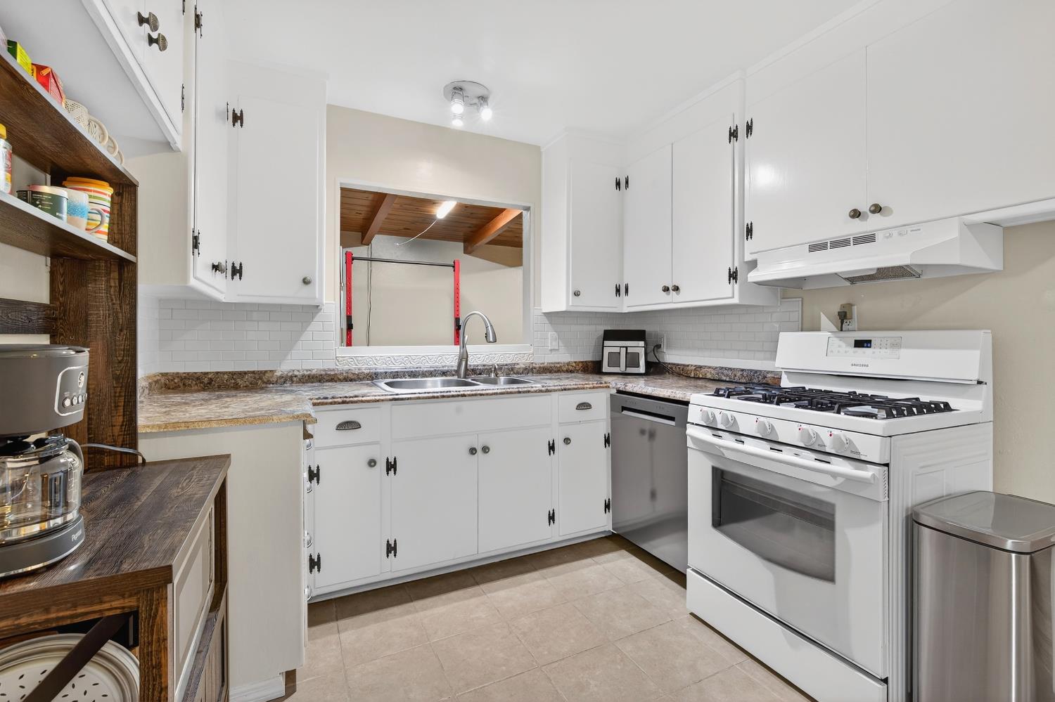 1507 West Locust Street Lodi, CA 95242 - Photo 9 of 28 a kitchen with granite countertop white cabinets and white appliances