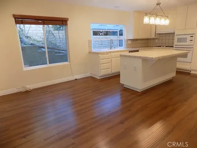 a large kitchen with stainless steel appliances wooden floors and view living room