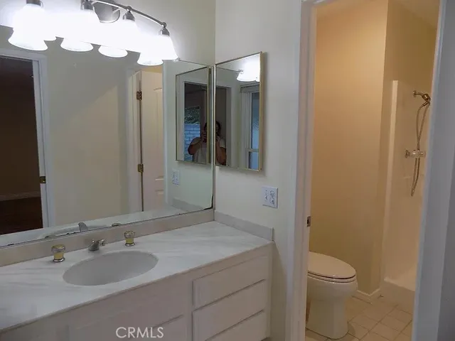 a bathroom with a granite countertop sink toilet and shower