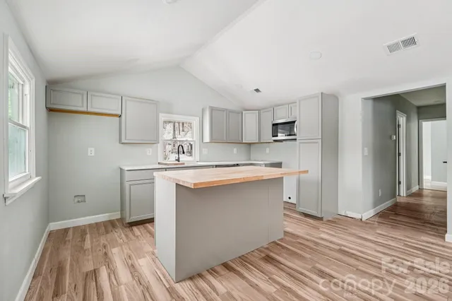 a kitchen with white cabinets and wooden floor