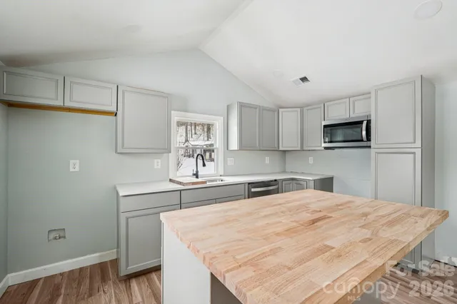 a kitchen with granite countertop a sink stove and microwave