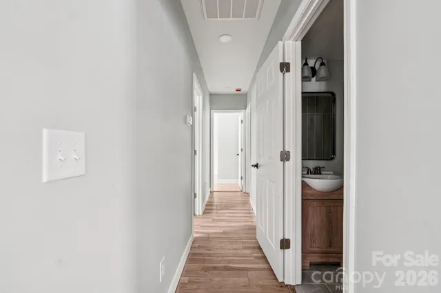 a view of a hallway with wooden floor and staircase
