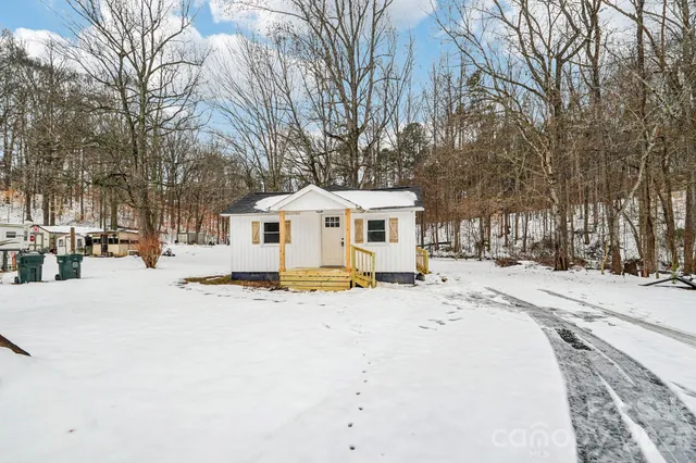 a view of a white house with a snow on the road