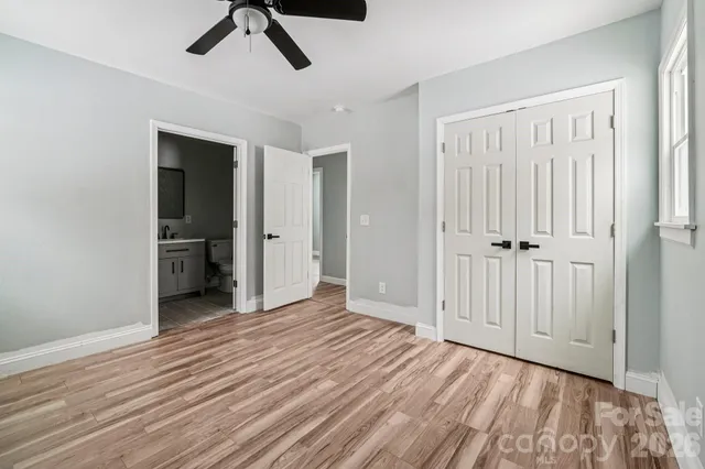 an empty room with wooden floor cabinet and windows
