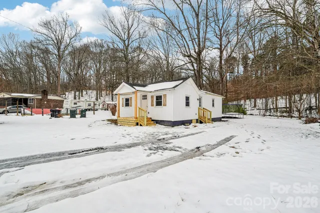 a view of a white house with a snow on the road