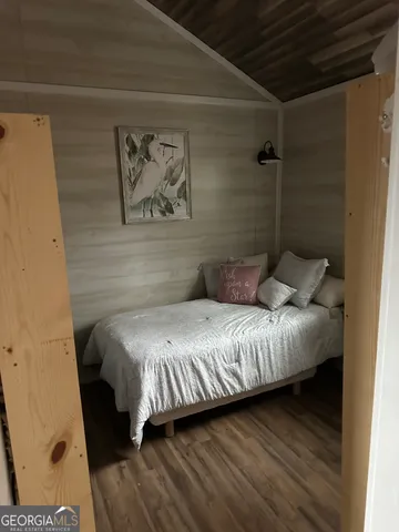 a bedroom with a bed and a painting on the wall