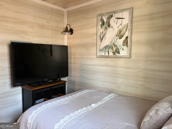 a bedroom with a bed and a flat screen tv