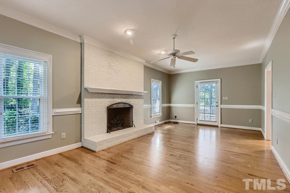 7301 Sandy Grove Court Raleigh, NC 27615 - Photo 4 of 28 a view of a livingroom with wooden floor a fireplace and windows