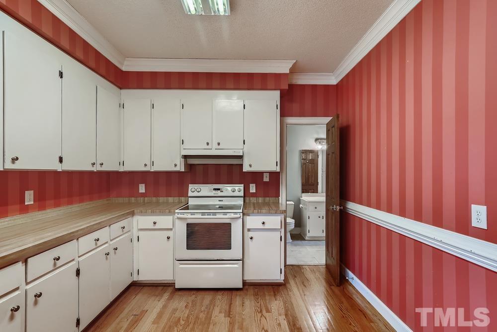 7301 Sandy Grove Court Raleigh, NC 27615 - Photo 10 of 28 a kitchen with stainless steel appliances white cabinets and wooden floors