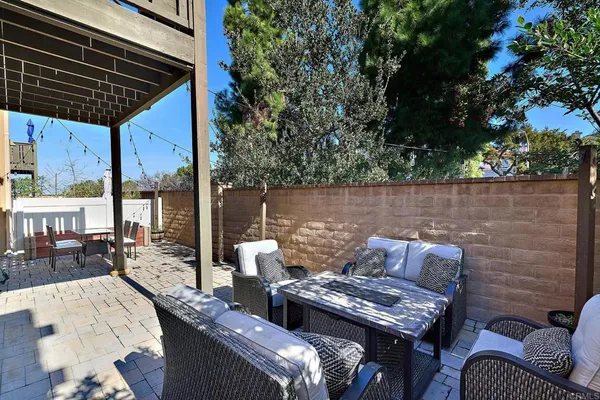 an outdoor living area with furniture and a fireplace