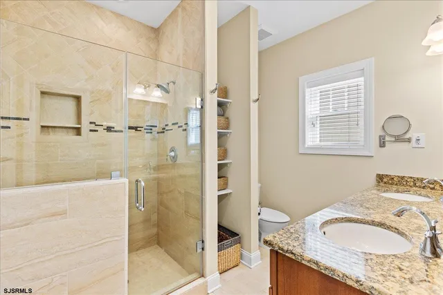 a bathroom with a granite countertop sink a mirror and a shower