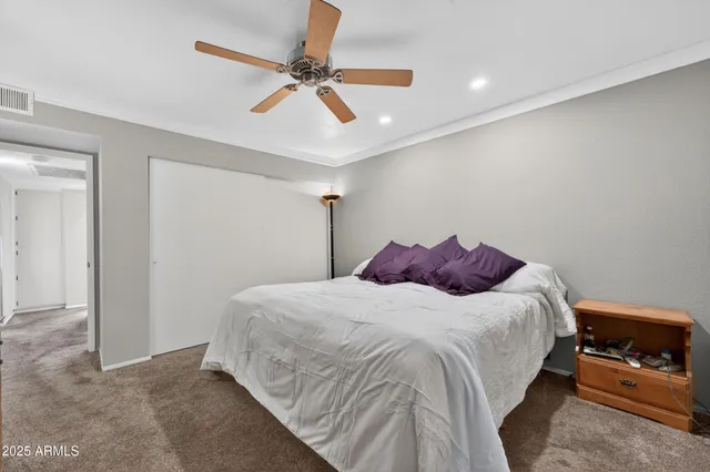 a bedroom with a bed and a ceiling fan
