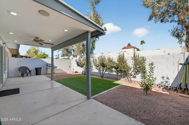 a view of a patio with table and chairs potted plants with floor to ceiling window