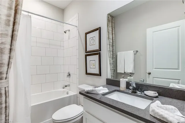 a bathroom with a granite countertop sink mirror toilet and bathtub