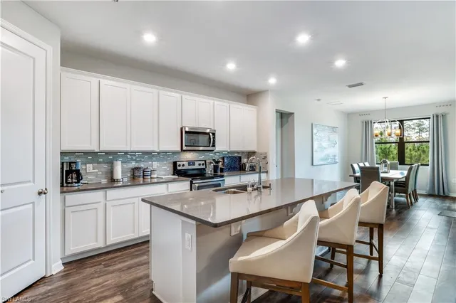 a kitchen with a dining table chairs sink and cabinets