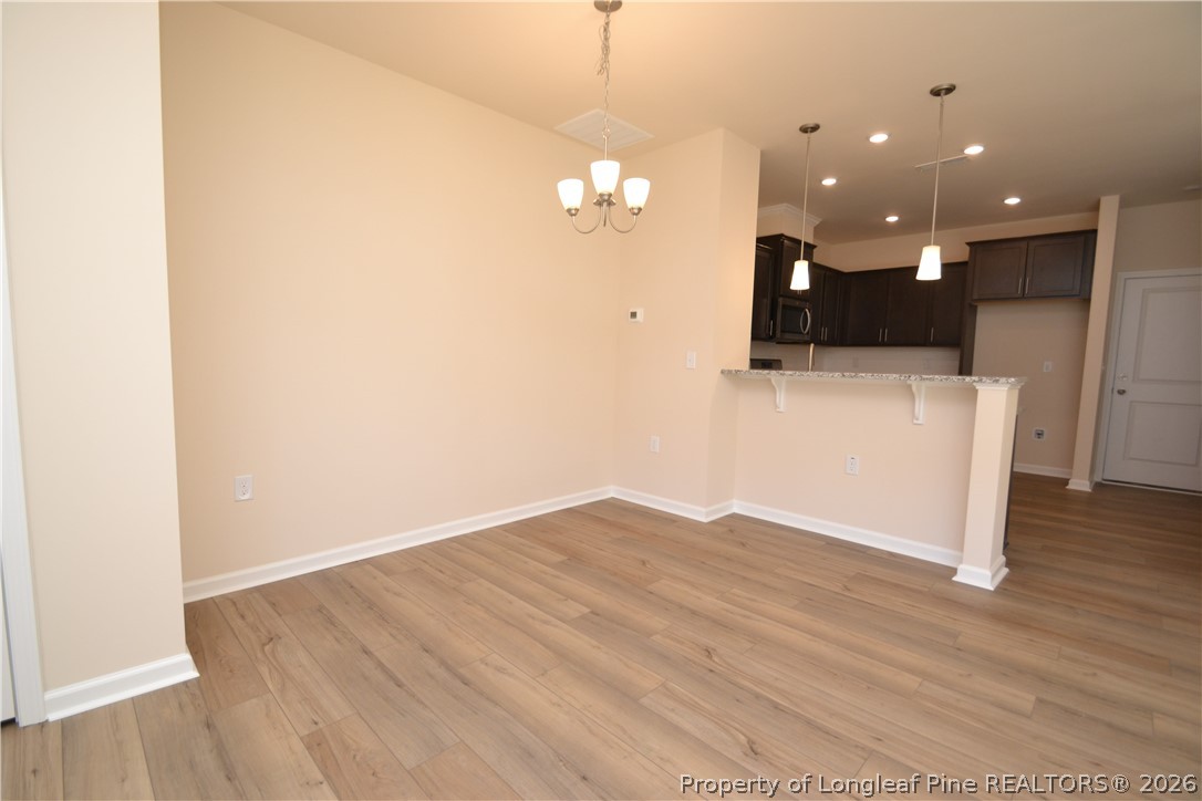 5703 Preveza Place Raleigh, NC 27603 - Photo 6 of 33 a view of empty room with wooden floor and ceiling fan