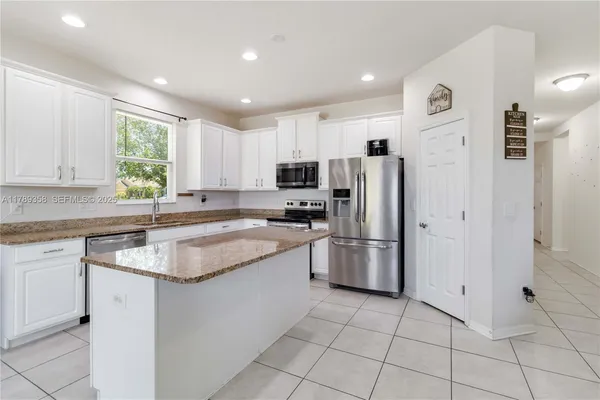 a kitchen with a refrigerator a sink and a stove top oven