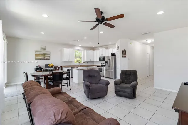 a living room with furniture and a dining table with kitchen view