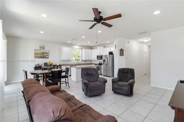 a living room with furniture and a dining table with kitchen view