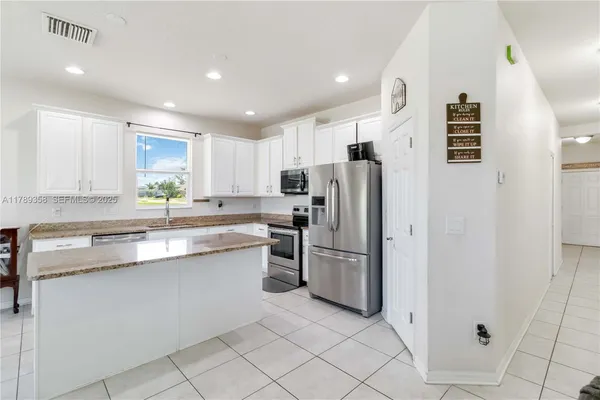 a kitchen with stainless steel appliances granite countertop a refrigerator and a sink