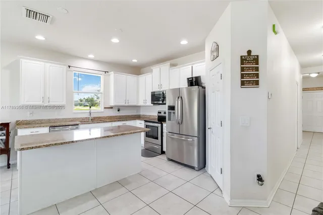 a kitchen with stainless steel appliances granite countertop a refrigerator and a sink