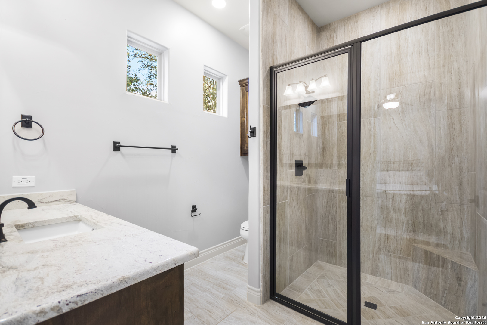 9 Ranch Brook Road Boerne, TX 78015 - Photo 31 of 59 a bathroom with a granite countertop sink a mirror and shower