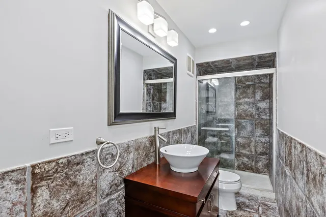 a spacious bedroom with a large bed and a chandelier