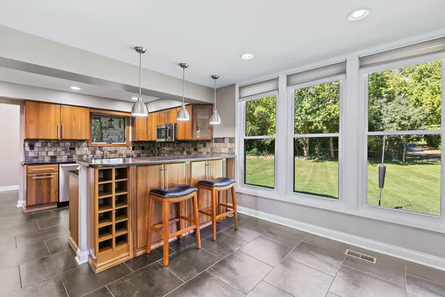 a kitchen with stainless steel appliances granite countertop wooden cabinets a sink and a counter top space