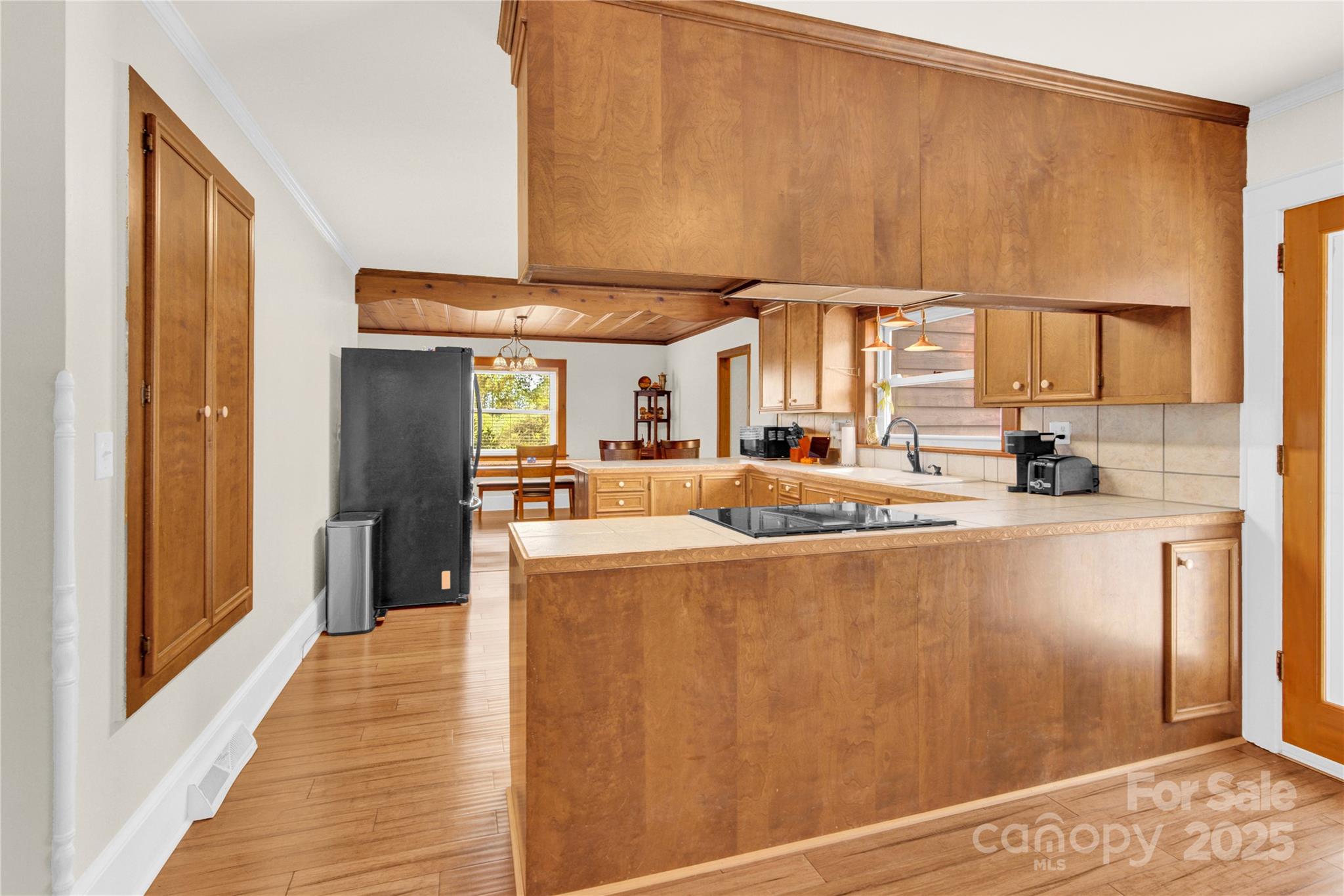 11720 Kluttz Road Gold Hill, NC 28071 - Photo 12 of 35 a view of a kitchen with kitchen island a counter top space a sink wooden floor and a refrigerator