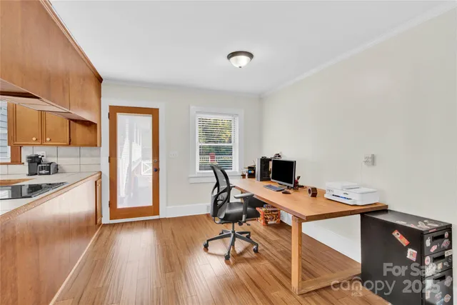 a view of a workspace with furniture and wooden floor