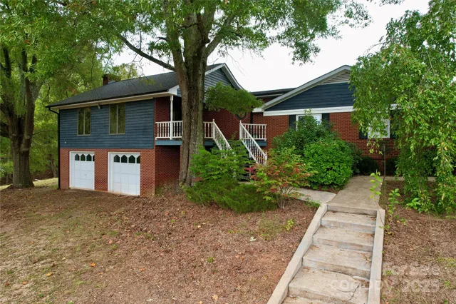 a front view of a house with a yard and trees