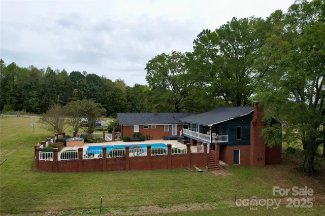 an aerial view of a house with swimming pool garden view and trees