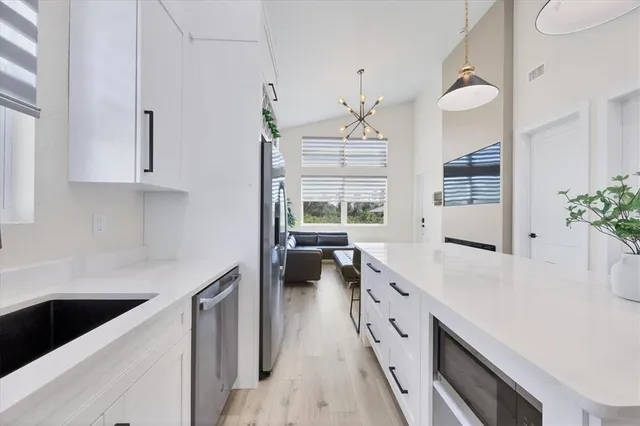 a kitchen with stainless steel appliances sink stove and cabinets