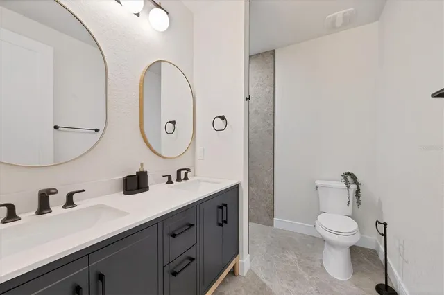 a bathroom with a toilet a sink and mirror