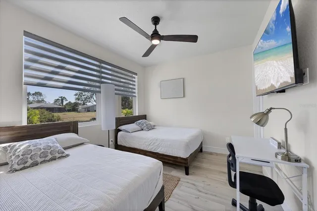 a bedroom with two beds and a large window