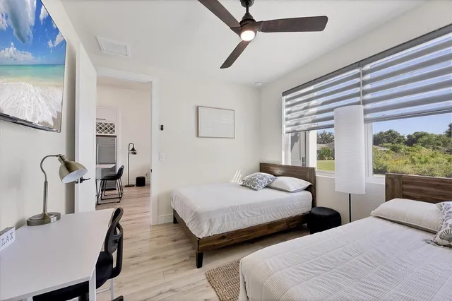 a bedroom with two beds and a large window