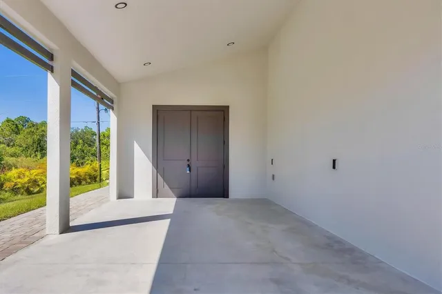 a view of an empty room with a floor to ceiling window and garden