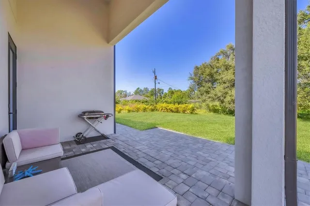 a view of a backyard with couches under an umbrella