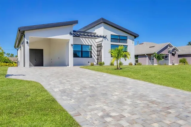 a view of a house with a small yard and potted plants