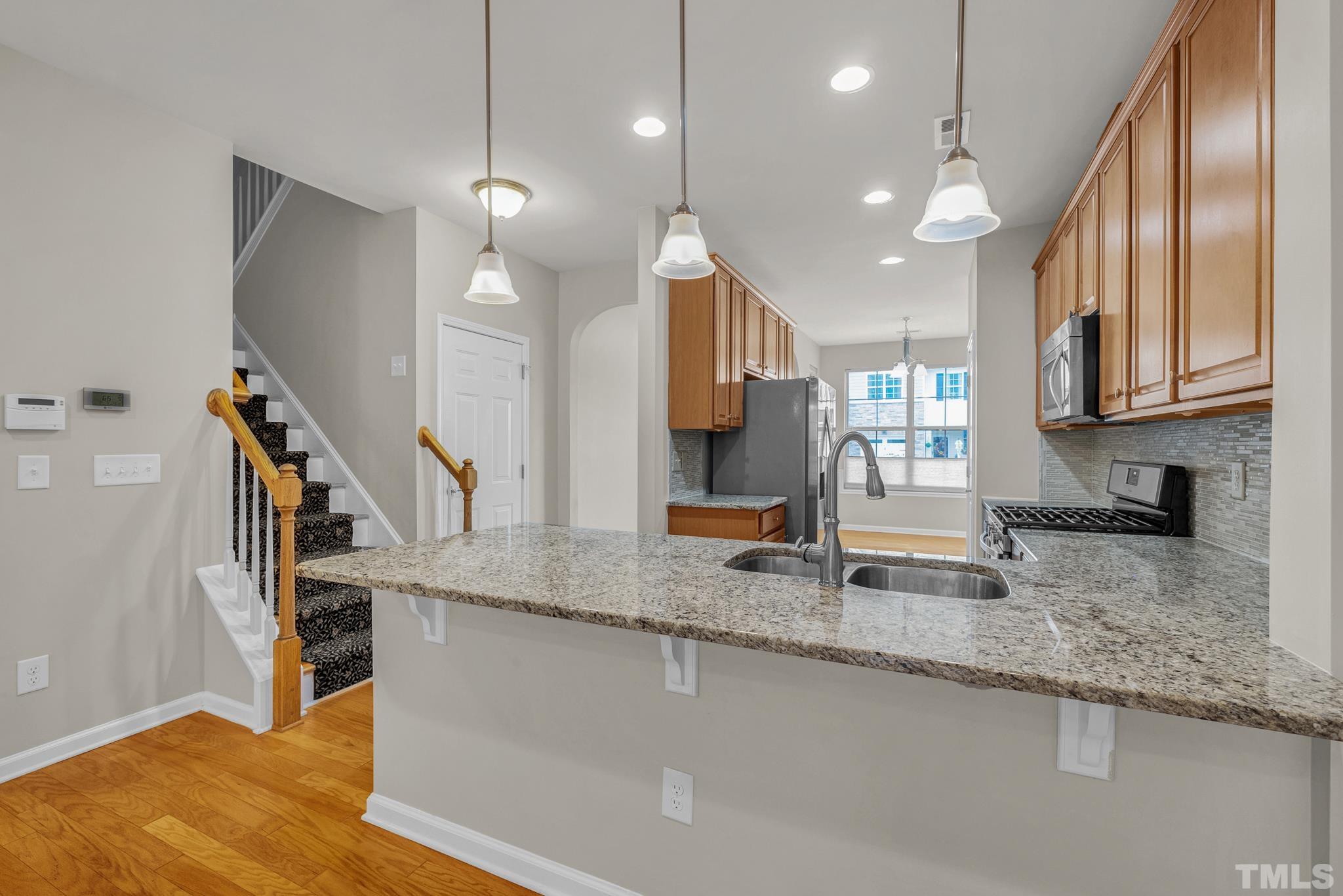 5 Intuition Circle Durham, NC 27705 - Photo 13 of 31 a kitchen with stainless steel appliances granite countertop a sink a refrigerator and a granite counter tops