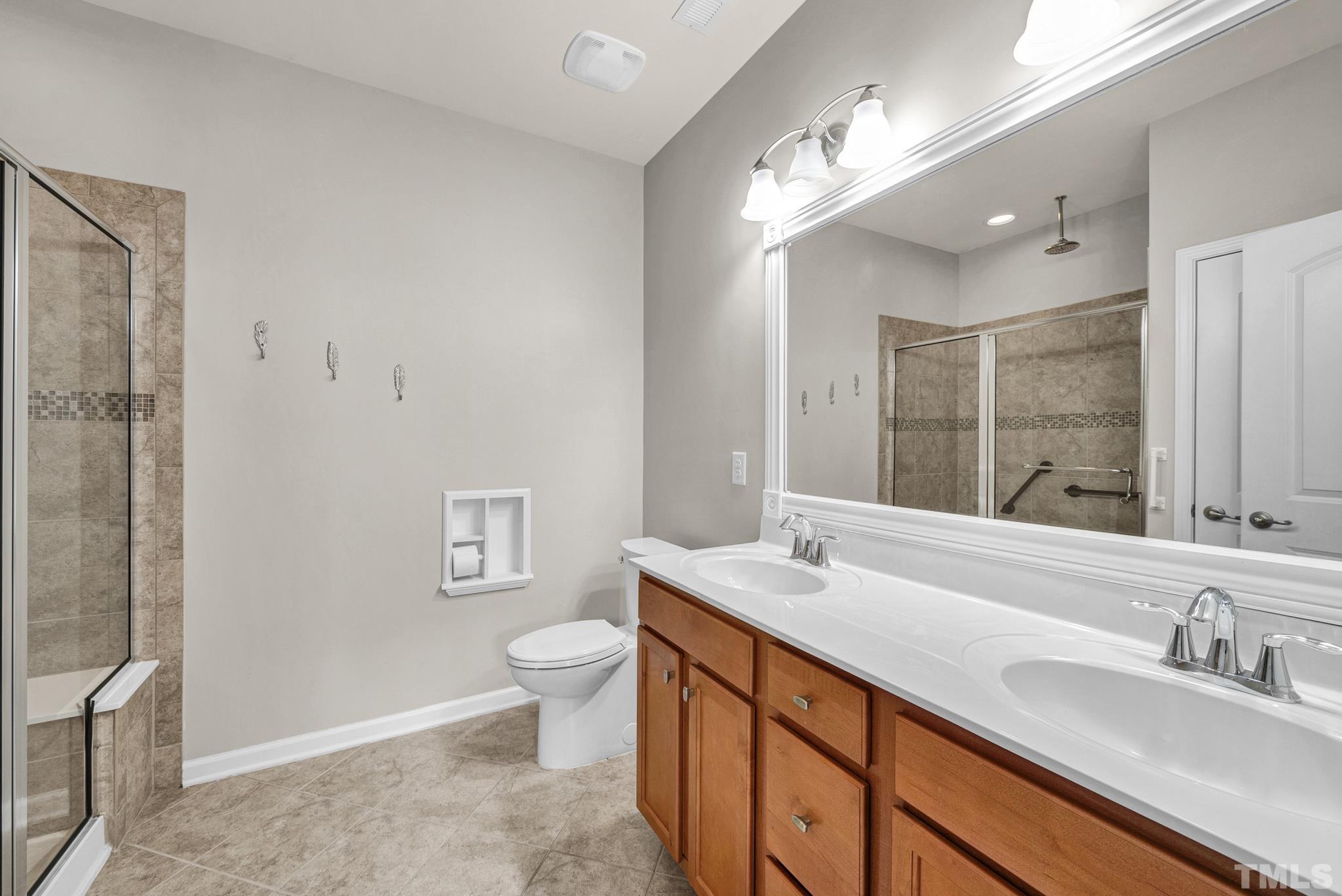 5 Intuition Circle Durham, NC 27705 - Photo 17 of 31 a bathroom with a granite countertop sink a toilet a mirror and a shower