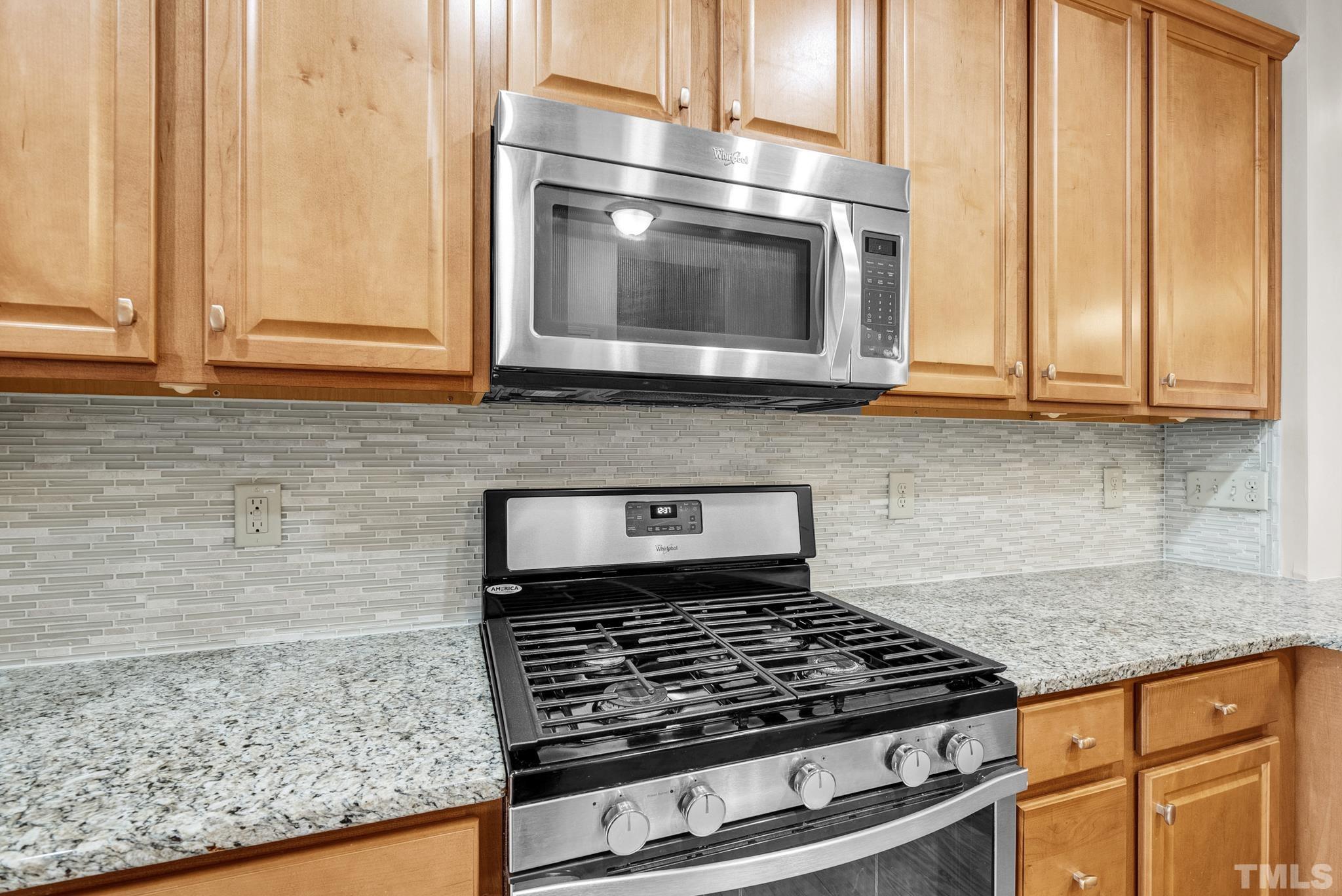 5 Intuition Circle Durham, NC 27705 - Photo 8 of 31 a kitchen with granite countertop a stove top oven cabinetry a sink and a window