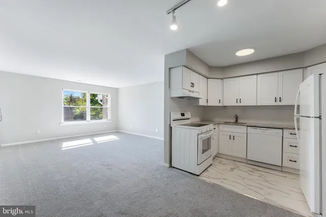 a kitchen with granite countertop white cabinets and white appliances